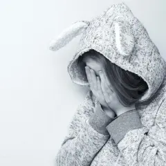 Smutna dziewczynka w bluzie z uszami, zakrywająca twarz dłońmi. Czyżby przeżywała trudne chwile, jak w opowieści o elicea?