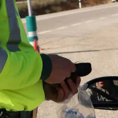 Policjant w kamizelce odblaskowej mierzy kierowcy trzeźwość. W Polsce obowiązują surowe przepisy dotyczące tego, ile promili można mieć we krwi.